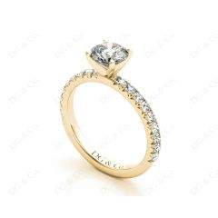 Round cut claw set diamond ring with pave set side stone in 18K Yellow