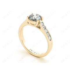 Round Cut 4 Claw Side Stone Engagement Ring with Channel Set Side Stones in 18K Yellow