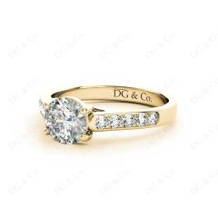 Round Cut 4 Claw Side Stone Engagement Ring with Channel Set Side Stones in 18K Yellow