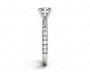 Round cut claw set diamond ring with pave set side stone in Platinum