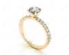 Round cut claw set diamond ring with pave set side stone in 18K Yellow