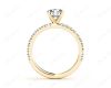 Round cut claw set diamond ring with pave set side stone in 18K Yellow