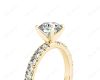 Round cut claw set diamond ring with pave set side stone in 18K Yellow