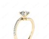 Round cut diamond cross over ring claw set diamond with pave set side stone in 18K Yellow