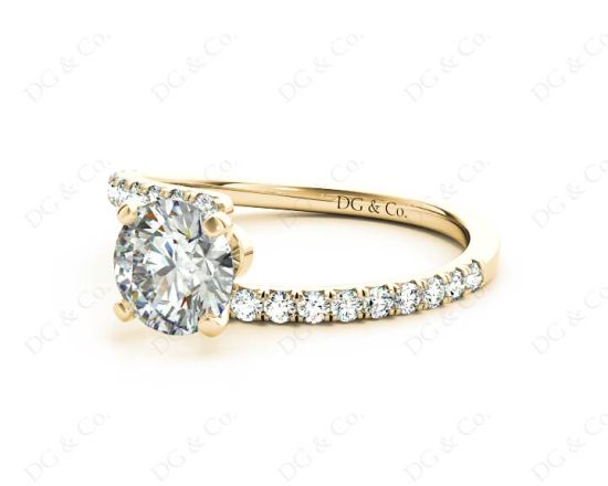 Round cut diamond cross over ring claw set diamond with pave set side stone in 18K Yellow